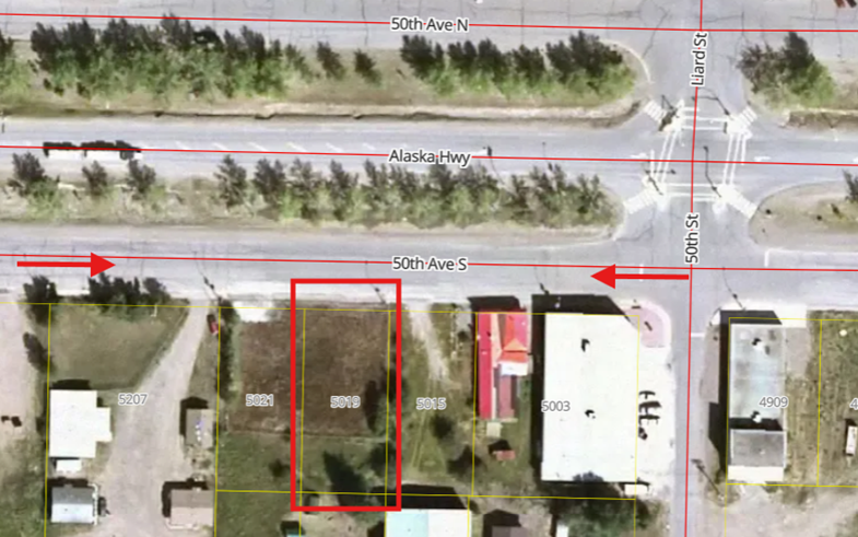 Satellite view of a street intersection with buildings and trees.